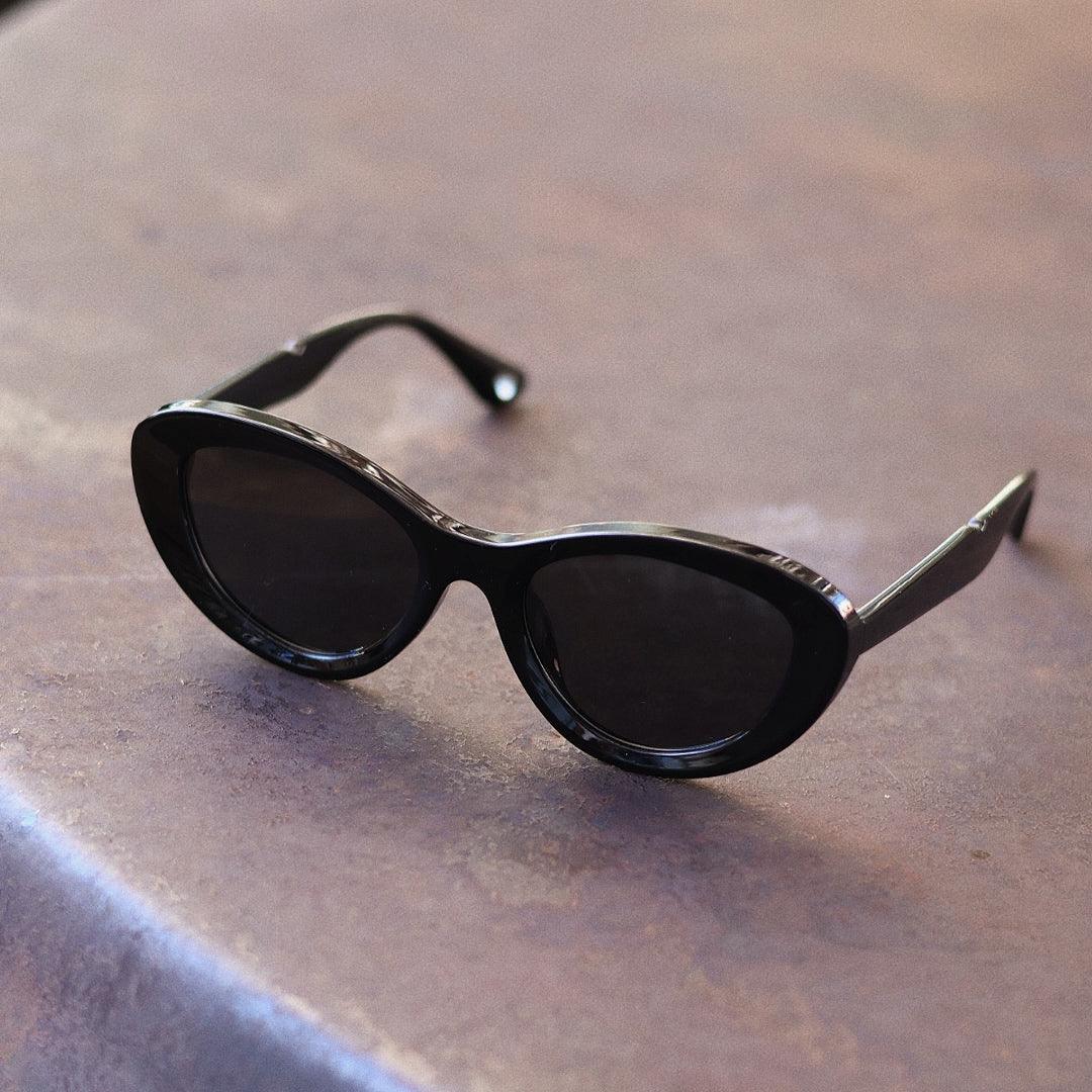 Stylish unisex cat-eye sunglasses by By Charley, featuring a black frame and polarized lenses that offer 100% UV protection and glare reduction for a confident, retro-inspired statement.