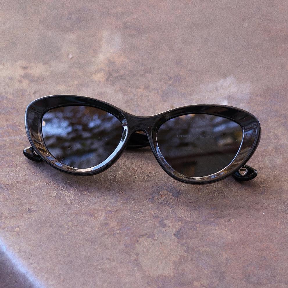 Stylish unisex cat-eye sunglasses by By Charley, featuring a black frame and polarized lenses that offer 100% UV protection and glare reduction for a confident, retro-inspired statement.