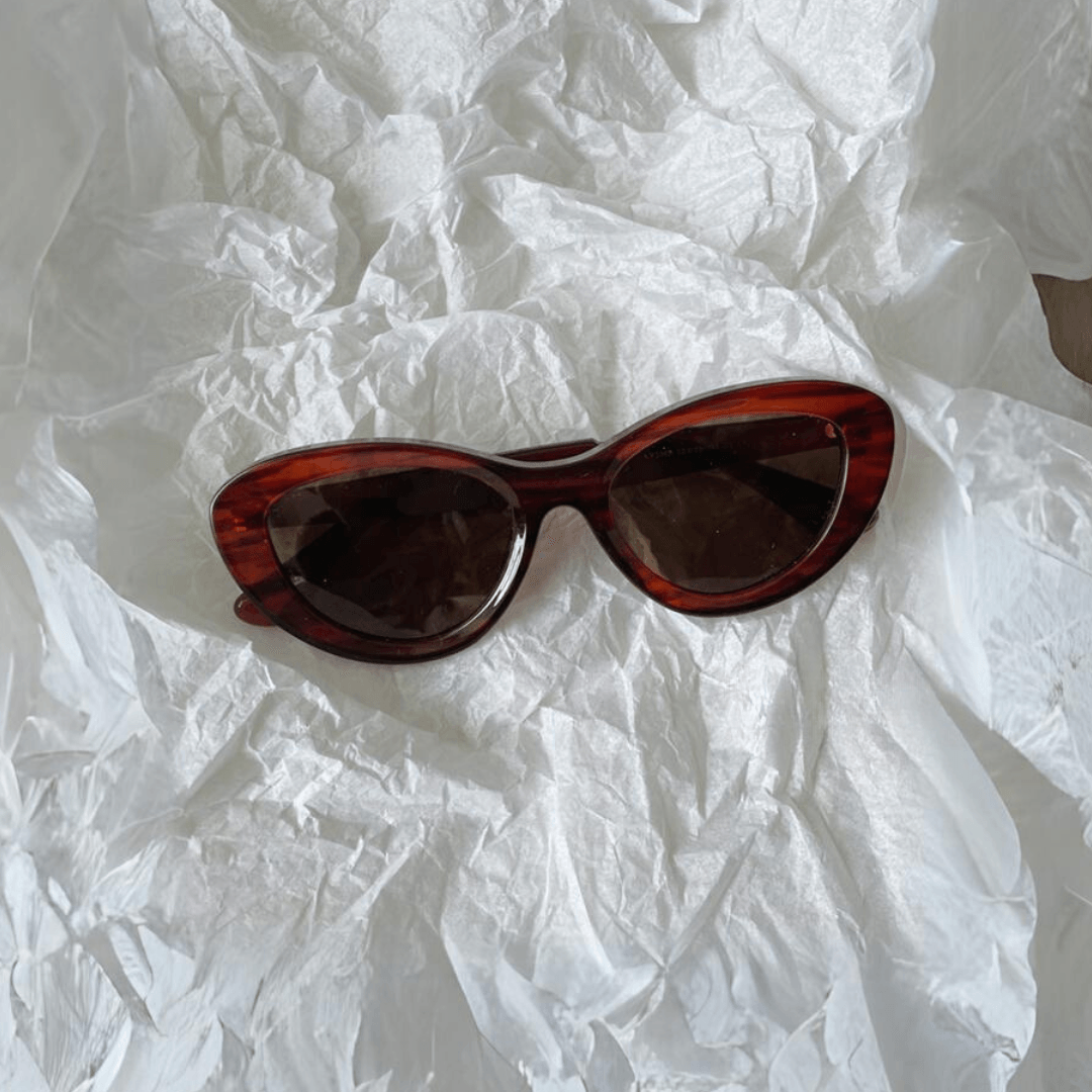 Stylish unisex cat-eye sunglasses by By Charley, featuring a rich reddish-brown frame and polarized lenses that offer 100% UV protection and glare reduction for a confident, retro-inspired statement.