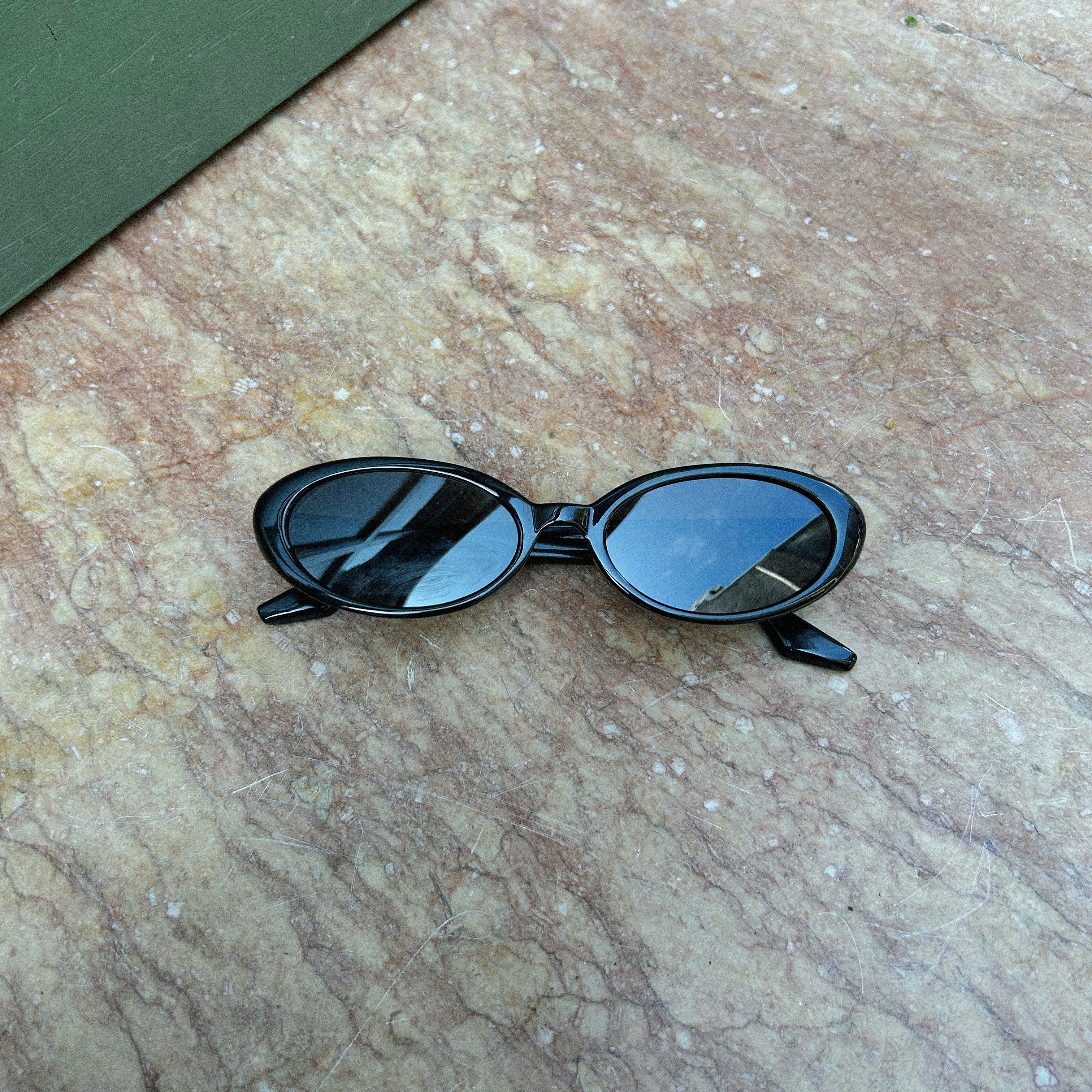 Embrace a fun vintage vibe with these By Charley unisex oval sunglasses in black with polarized lenses for a playful retro look.