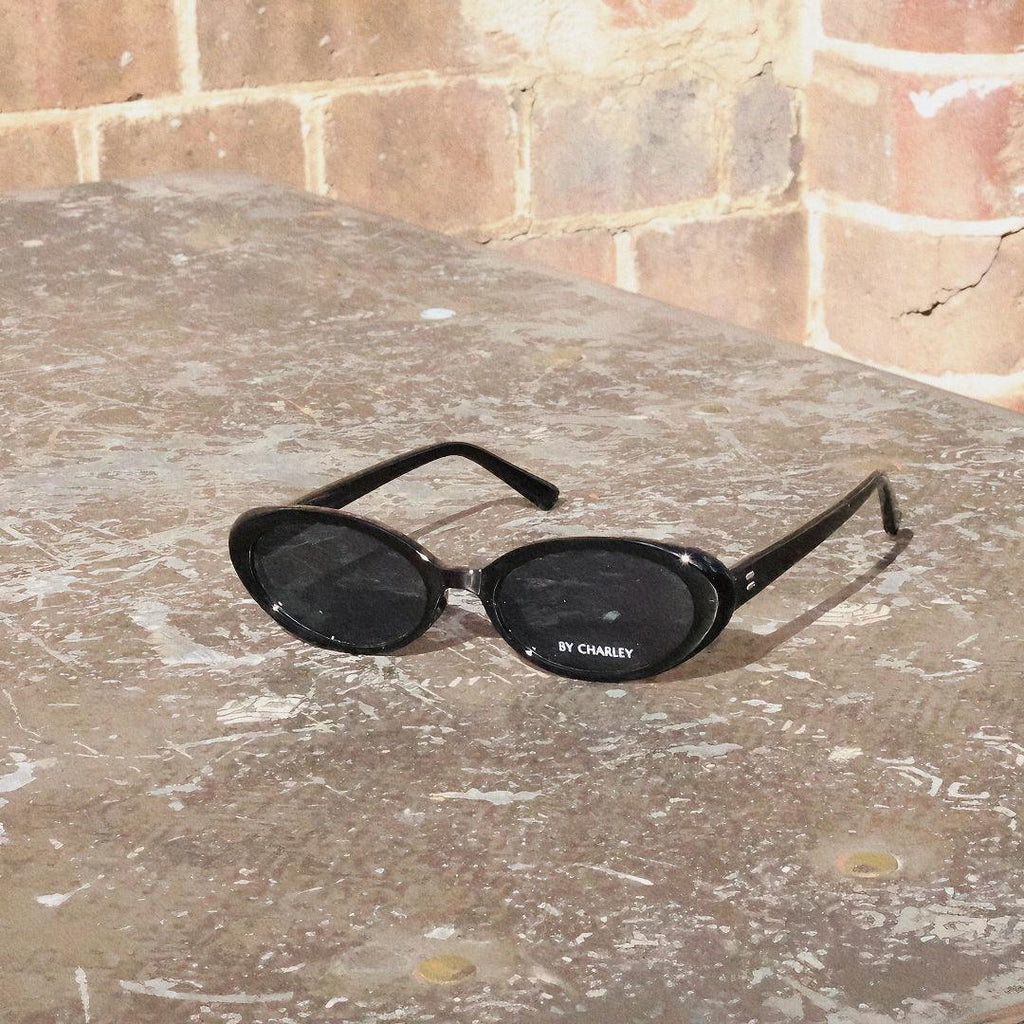 Embrace a fun vintage vibe with these By Charley unisex oval sunglasses in black with polarized lenses for a playful retro look.