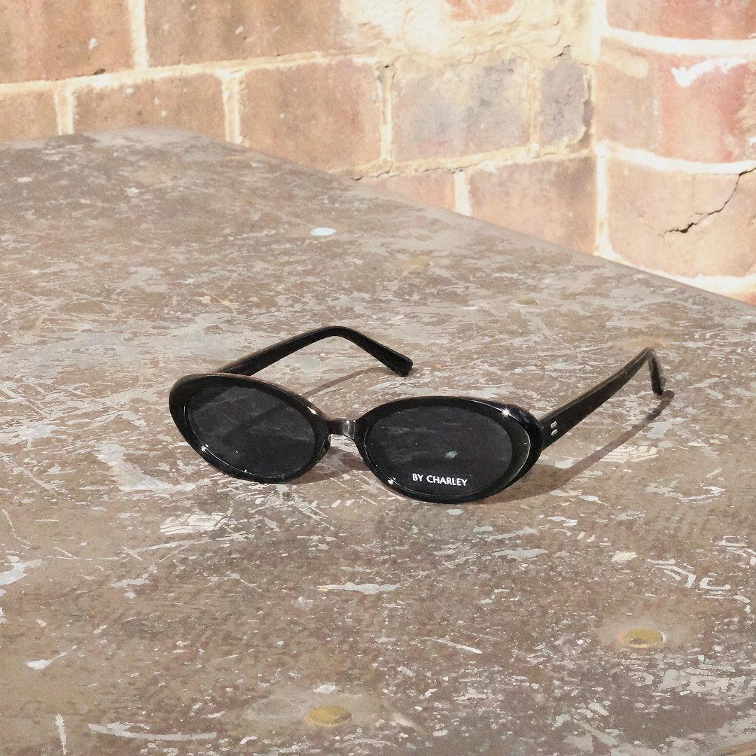 Embrace a fun vintage vibe with these By Charley unisex oval sunglasses in black with polarized lenses for a playful retro look.