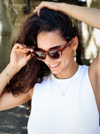 Stylish unisex cat-eye sunglasses by By Charley, featuring a rich reddish-brown frame and polarized lenses that offer 100% UV protection and glare reduction for a confident, retro-inspired statement.