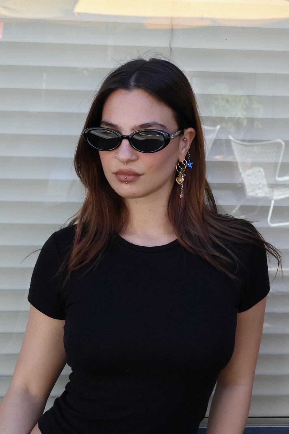 Embrace a fun vintage vibe with these By Charley unisex oval sunglasses in black with polarized lenses for a playful retro look.