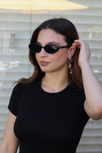 Embrace a fun vintage vibe with these By Charley unisex oval sunglasses in black with polarized lenses for a playful retro look.