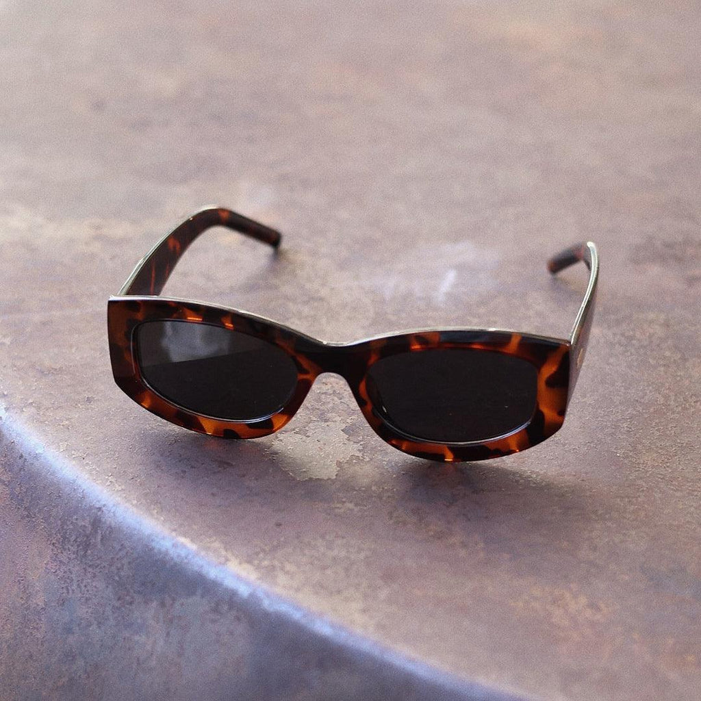 Bold unisex square sunglasses by By Charley, featuring a chunky tortoiseshell frame and polarized lenses that provide 100% UV protection and anti-glare functionality for a confident, architectural aesthetic.