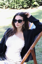 Stylish unisex cat-eye sunglasses by By Charley, featuring a black frame and polarized lenses that offer 100% UV protection and glare reduction for a confident, retro-inspired statement.