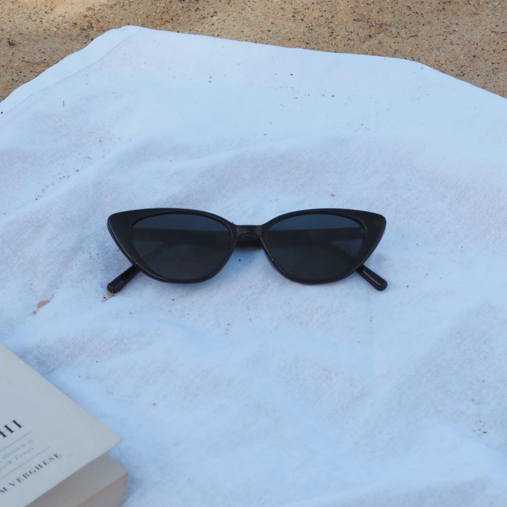 Embrace a playful and dramatic retro vibe with these By Charley unisex black cat-eye sunglasses featuring polarized lenses.