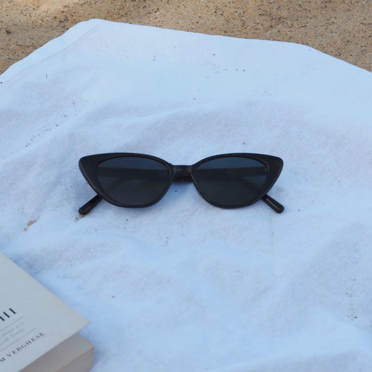 Embrace a playful and dramatic retro vibe with these By Charley unisex black cat-eye sunglasses featuring polarized lenses.